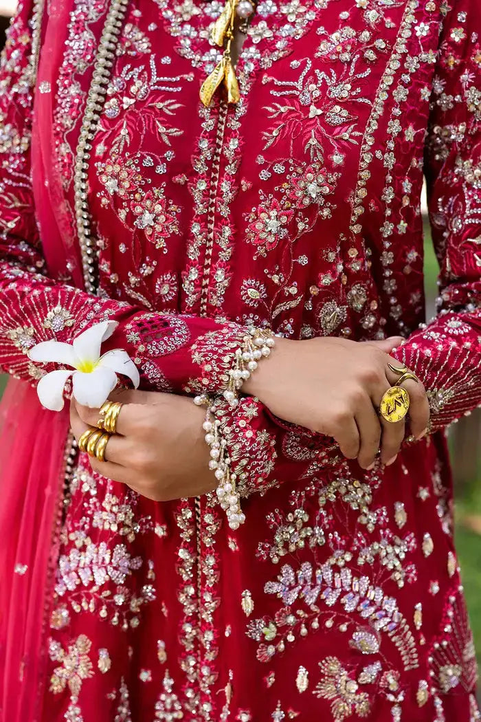 Close-up of GOLNAR-SRF25-01 Saira Rizwan Sharara sleeve and jewelry, emphasizing intricate embroidery and luxury embellishments on red silk.