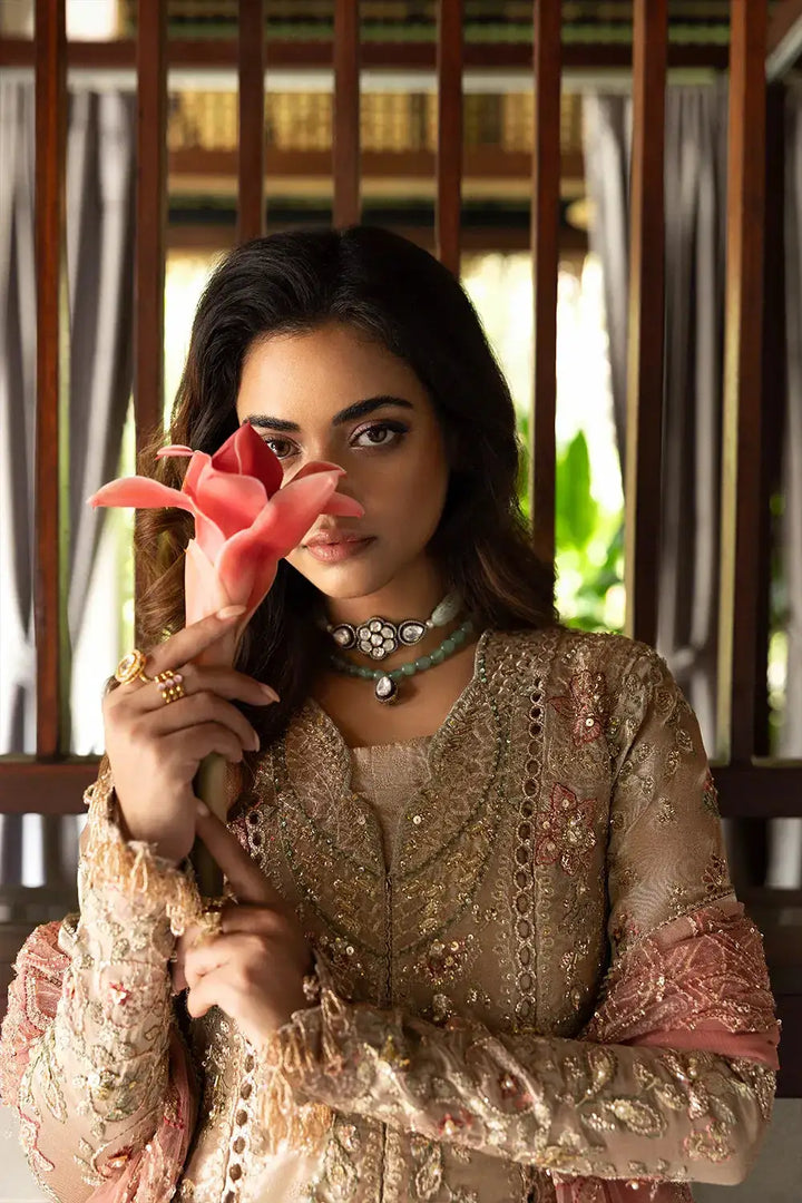 Model holding flower in ROHANA-SRF25-03 by Saira Rizwan, focusing on hand embellishments and zari detailing on organza shirt and dupatta.