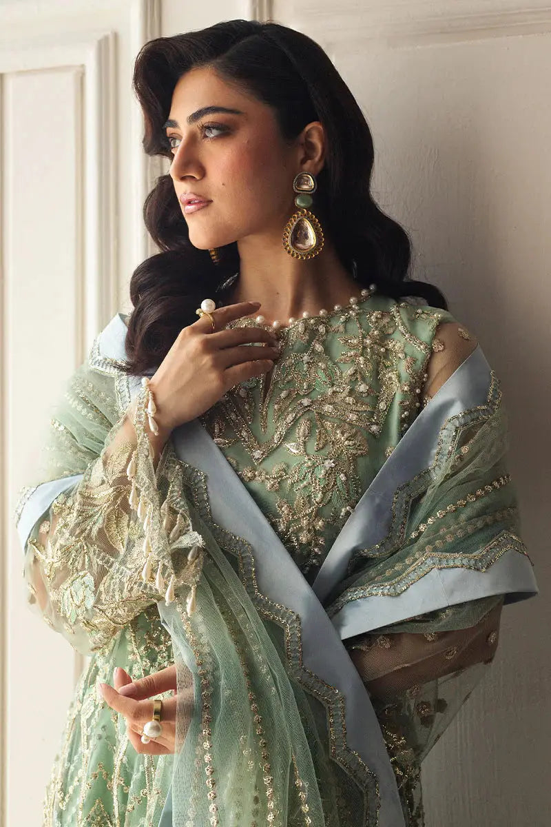 Model wearing MUSHQ Green Pistachio Dress with pearl accessories, showcasing embroidered net fabric and elegant formal design.