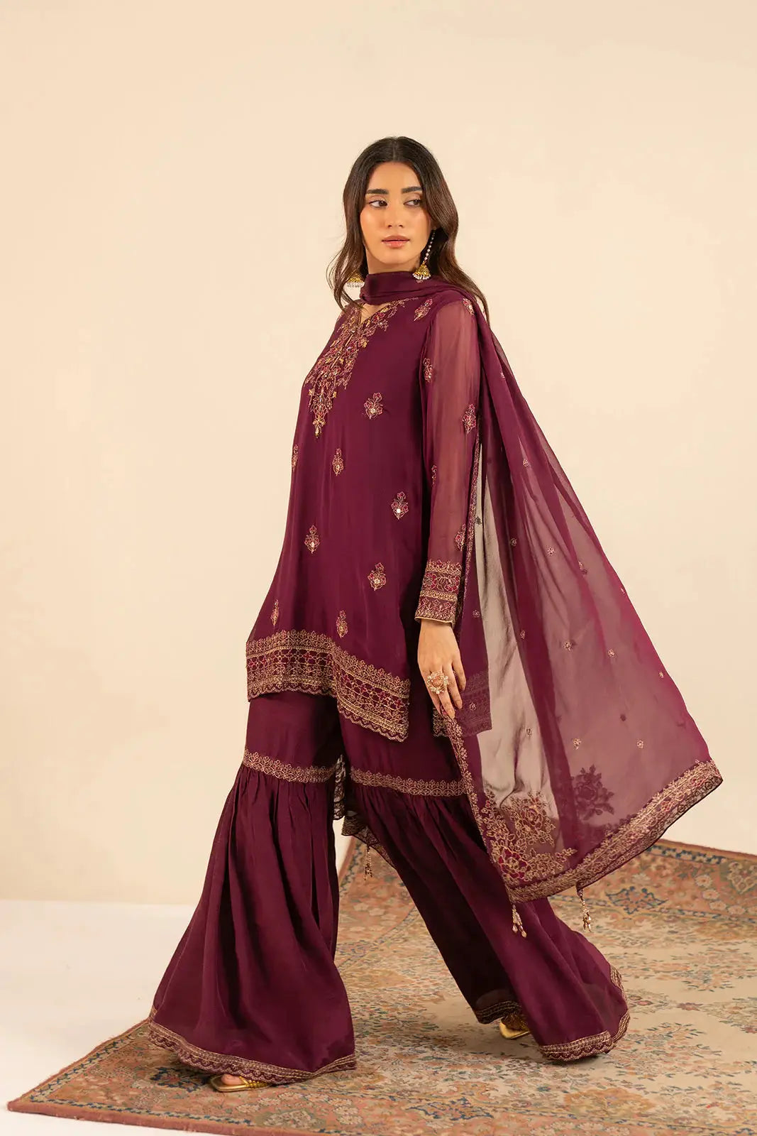 Side pose of CHINYERE Embroidered Suit - Chiffon Dresses | 3 Piece Set featuring detailed embellishments and flared gharara pants.