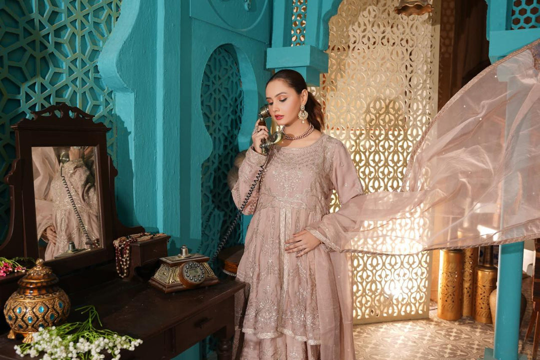 Woman in embroidered dress holding vintage phone.