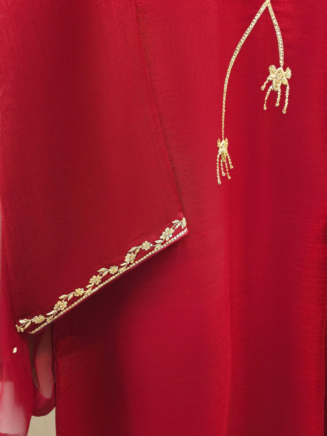 Detailed sleeve embroidery of AGHA NOOR 3 Piece Suit, featuring gold floral patterns on sheer red cotton net for a refined traditional look.