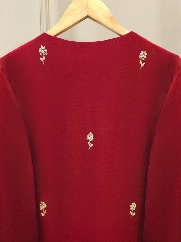 Back embroidery detail of AGHA NOOR Embroidered Suit - USA | Cotton Elegance, showcasing small gold floral motifs on rich red cotton net fabric.