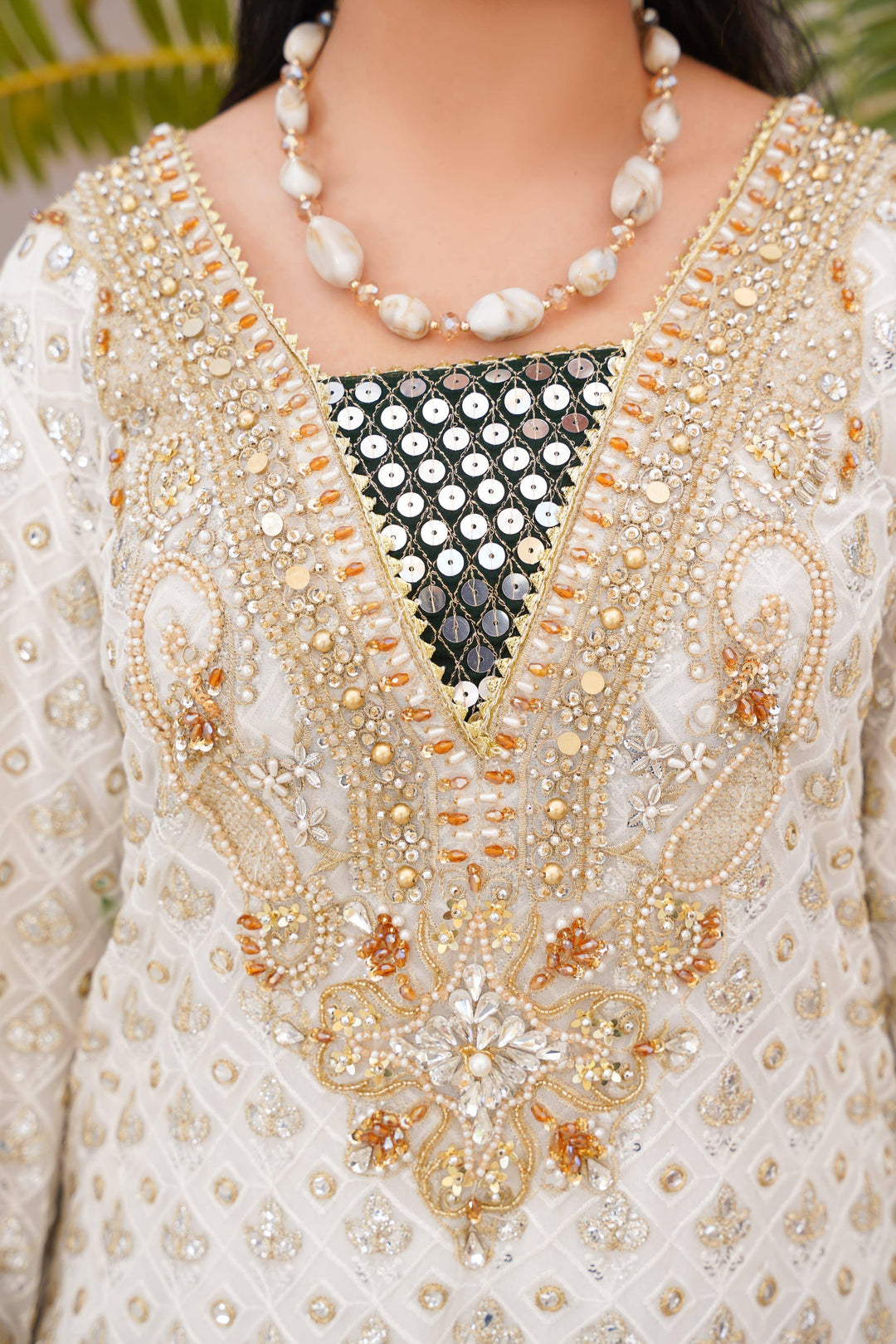 Close-up of RANGREZA SAJNI neckline embroidery with pearls, sequins, and gold threadwork, highlighting premium festive detailing.