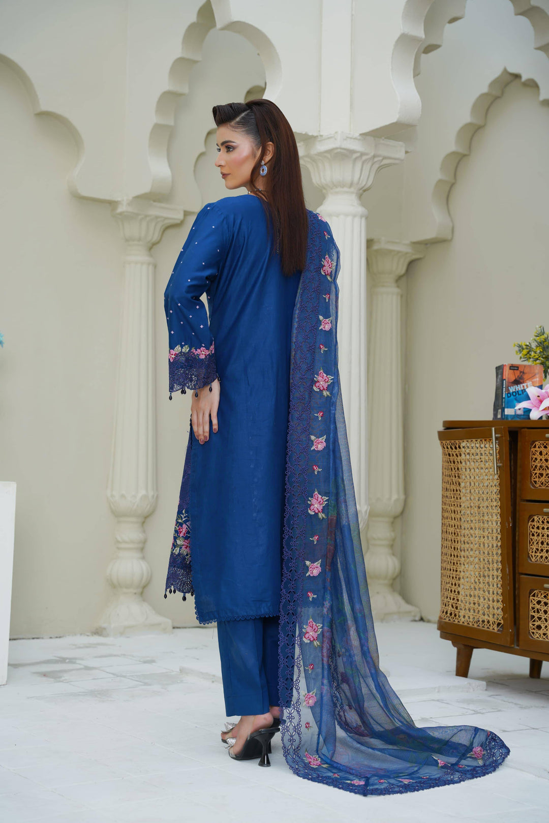 Back view of RANGREZA SAJNI RS-3518-1000 Pakistani suit showcasing plain blue shirt and floral embroidered dupatta in a traditional setting.