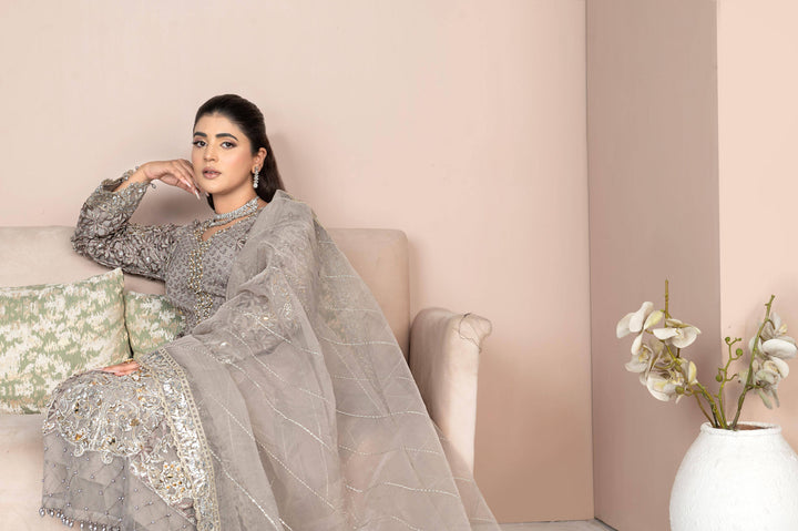 Model seated in RANGREZA SAJNI RS-3528-1300 grey organza shirt, grip trousers, and embroidered dupatta. Elegant Pakistani designer fashion.