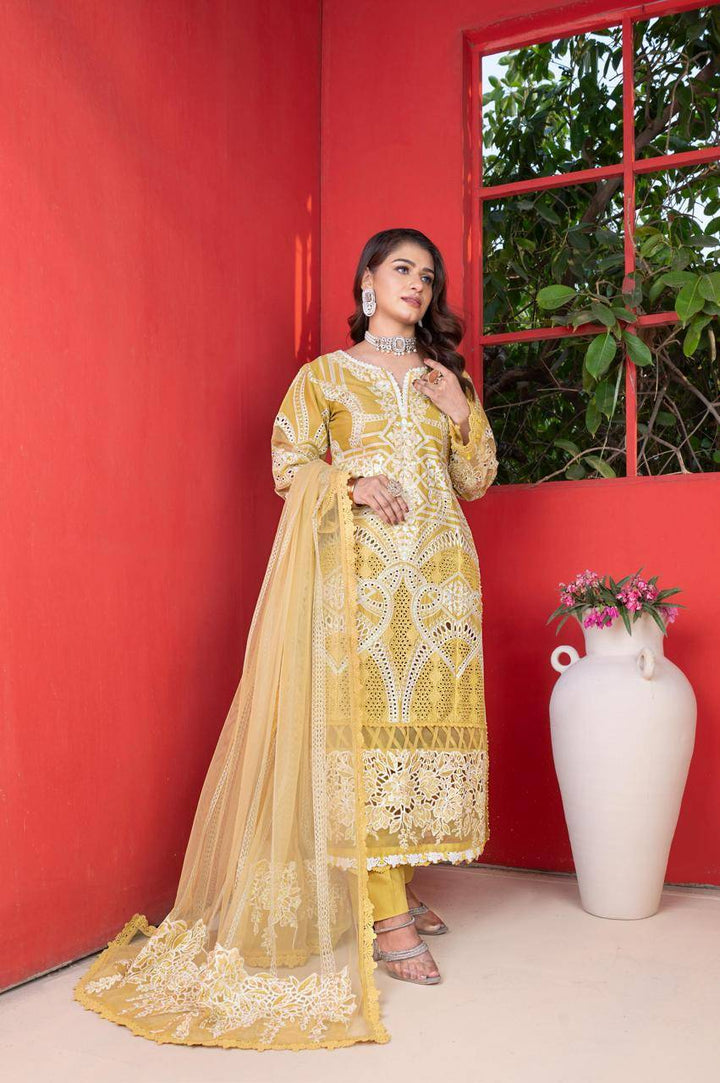 RANGREZA SAJNI RS-3503-1200 yellow embroidered shirt pants and dupatta set, Pakistani dress for women, styled against red wall.