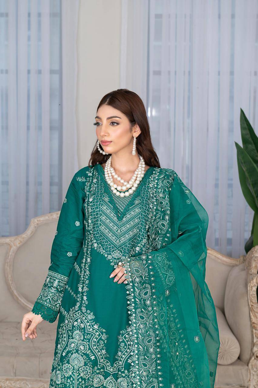 Close-up of Rangreza Sajni green embroidered shirt with pearl jewelry, highlighting detailed neckline and sleeve patterns.