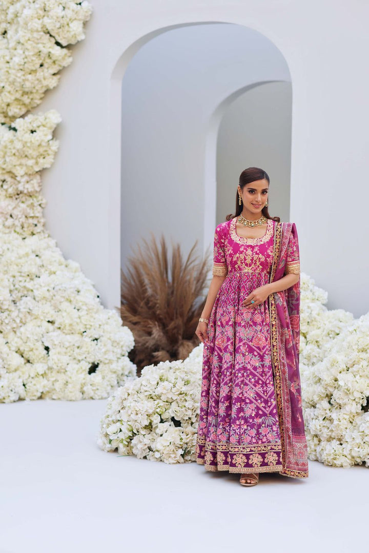 Mina Hasan pink floral embroidered shirt and dupatta set, model standing in front of a white arch and floral decor.