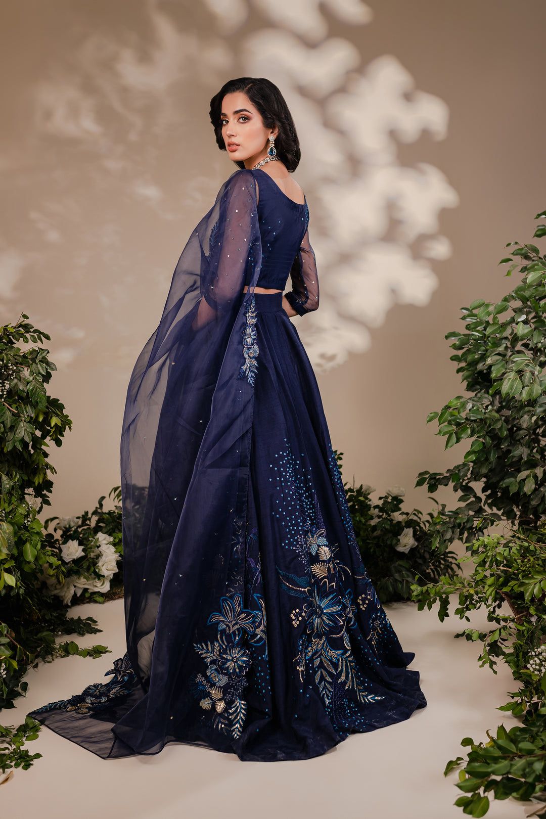 Back view of Batik Arden 3 Piece outfit showcasing intricate floral embroidery on navy blue raw silk lehnga and sheer dupatta.