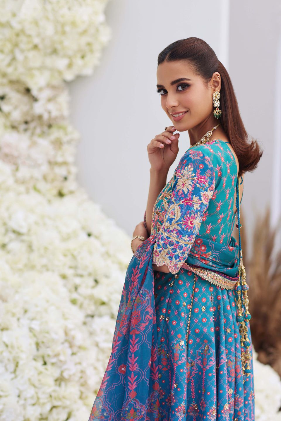 Side view of Mina Hasan blue embroidered shirt with floral patterns and tassel back, styled with gold earrings and bracelet.