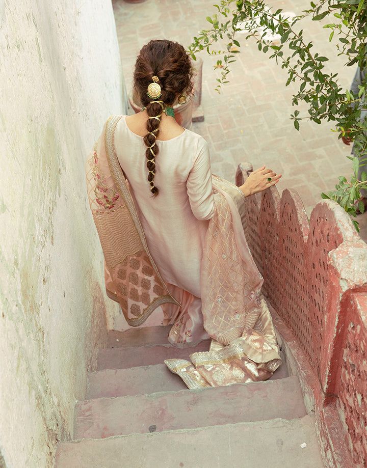 Back view of Faiza Saqlain Gulfam outfit featuring embroidered organza dupatta and raw silk shirt, ideal for bridal trousseau styling.