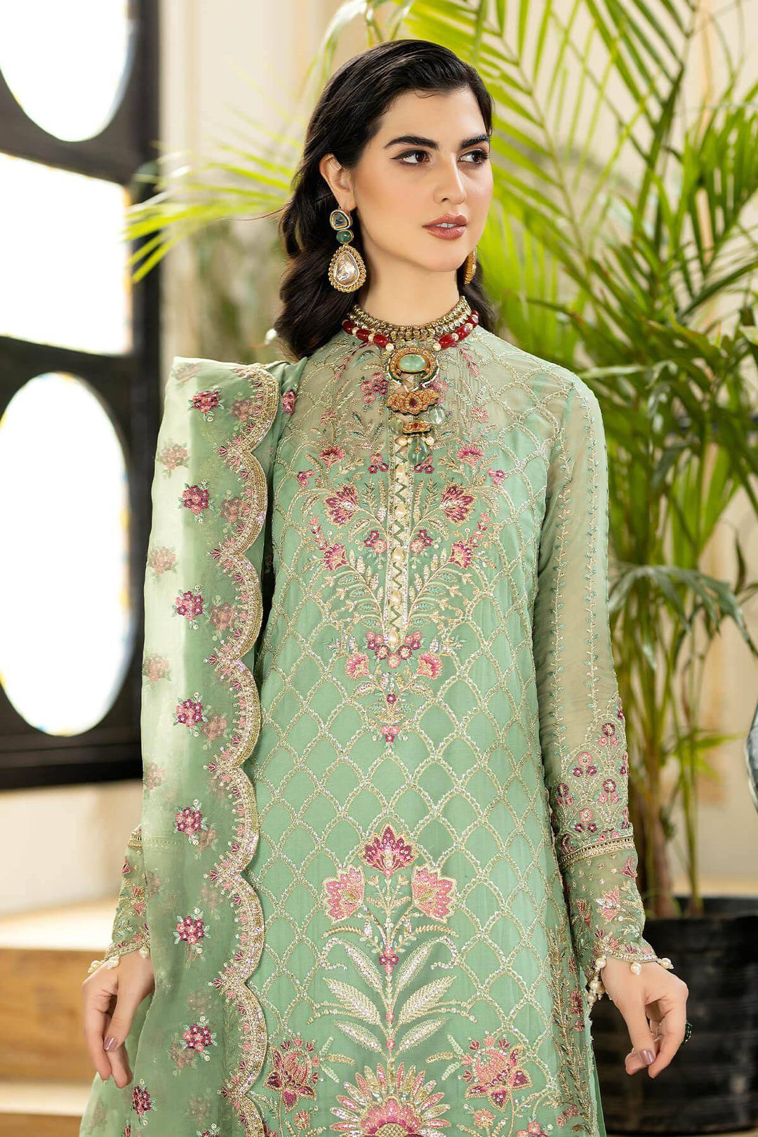 Close-up of embroidered green dress with intricate details