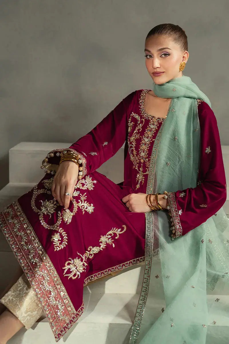 Seated model in MUSHQ Velvet - Ruby Maroon Shirt Set showcasing detailed embroidery and contrast between maroon velvet and mint dupatta.