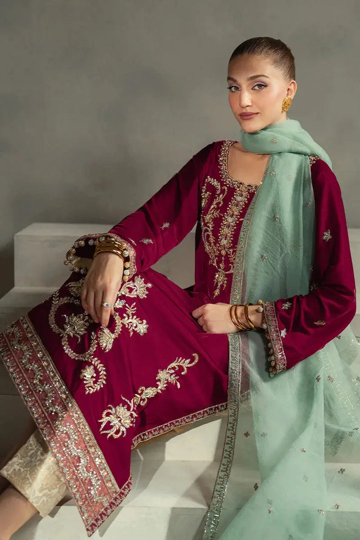 Seated model in MUSHQ Velvet - Ruby Maroon Shirt Set showcasing detailed embroidery and contrast between maroon velvet and mint dupatta.