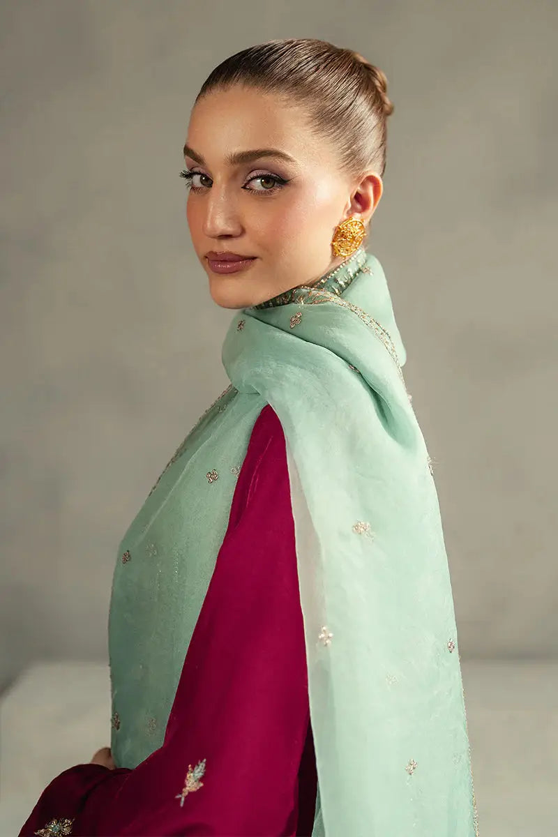Profile shot of model in MUSHQ Velvet - Ruby Maroon Shirt Set with mint green dupatta wrapped around neck, showcasing earrings and embroidery.