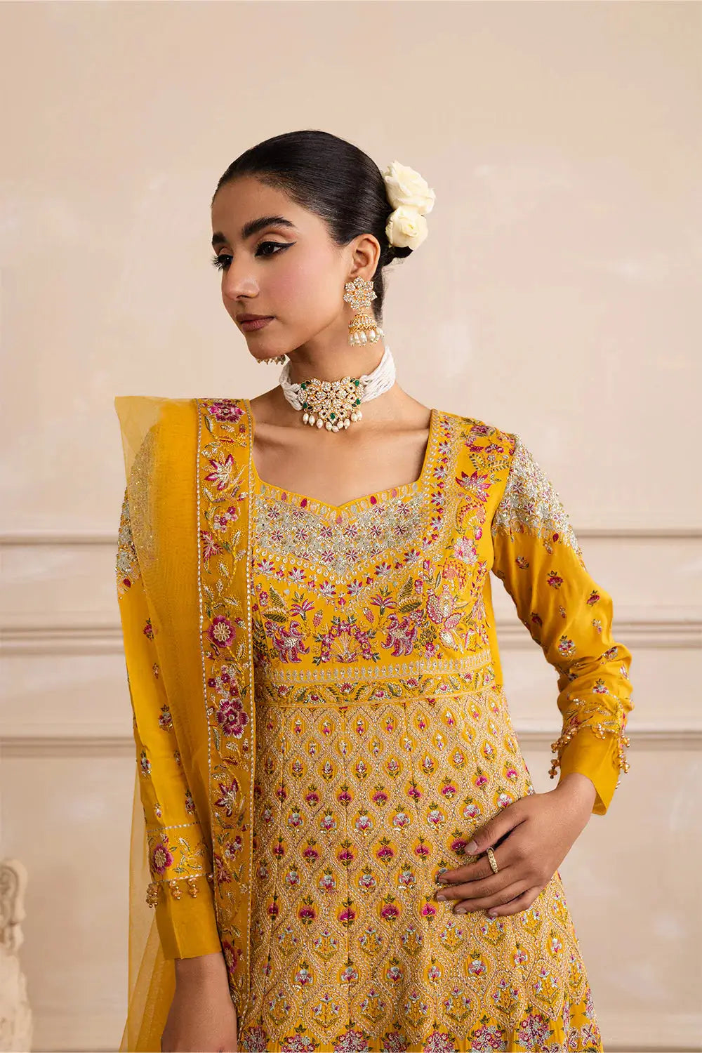 Close-up of MARYUM N MARIA ZARINA Anarkali dress showing floral embroidery on bodice and sleeves with sweetheart neckline in vibrant yellow.