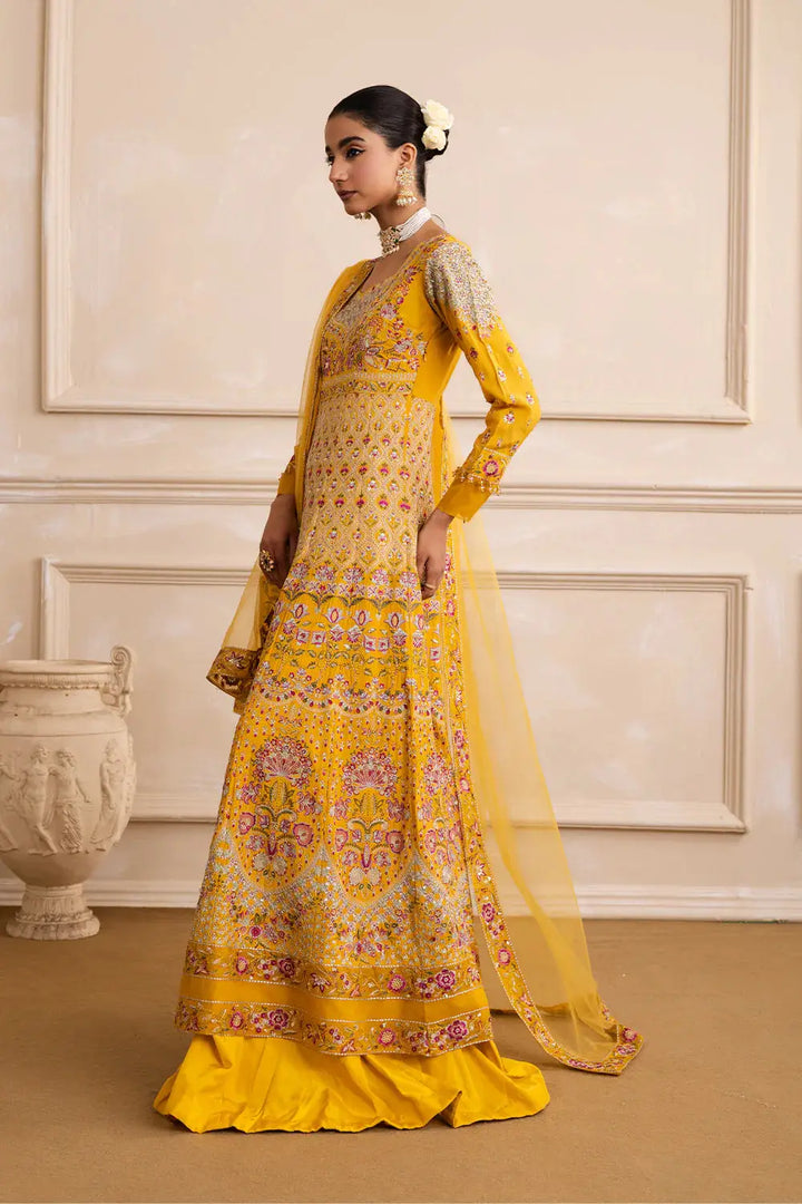 Side view of MARYUM N MARIA ZARINA Mehendi Anarkali dress in yellow with intricate kalidar design and embroidered dupatta for festive wear.