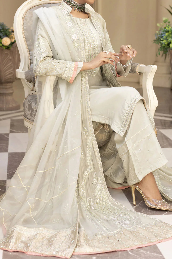 Seated view of woman in light grey Pakistan gown dress with embroidered dupatta and pants, perfect for elegant events.
