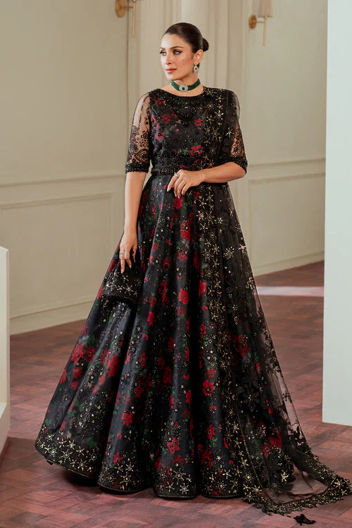 Woman wearing a black floral evening gown in an elegant indoor setting.