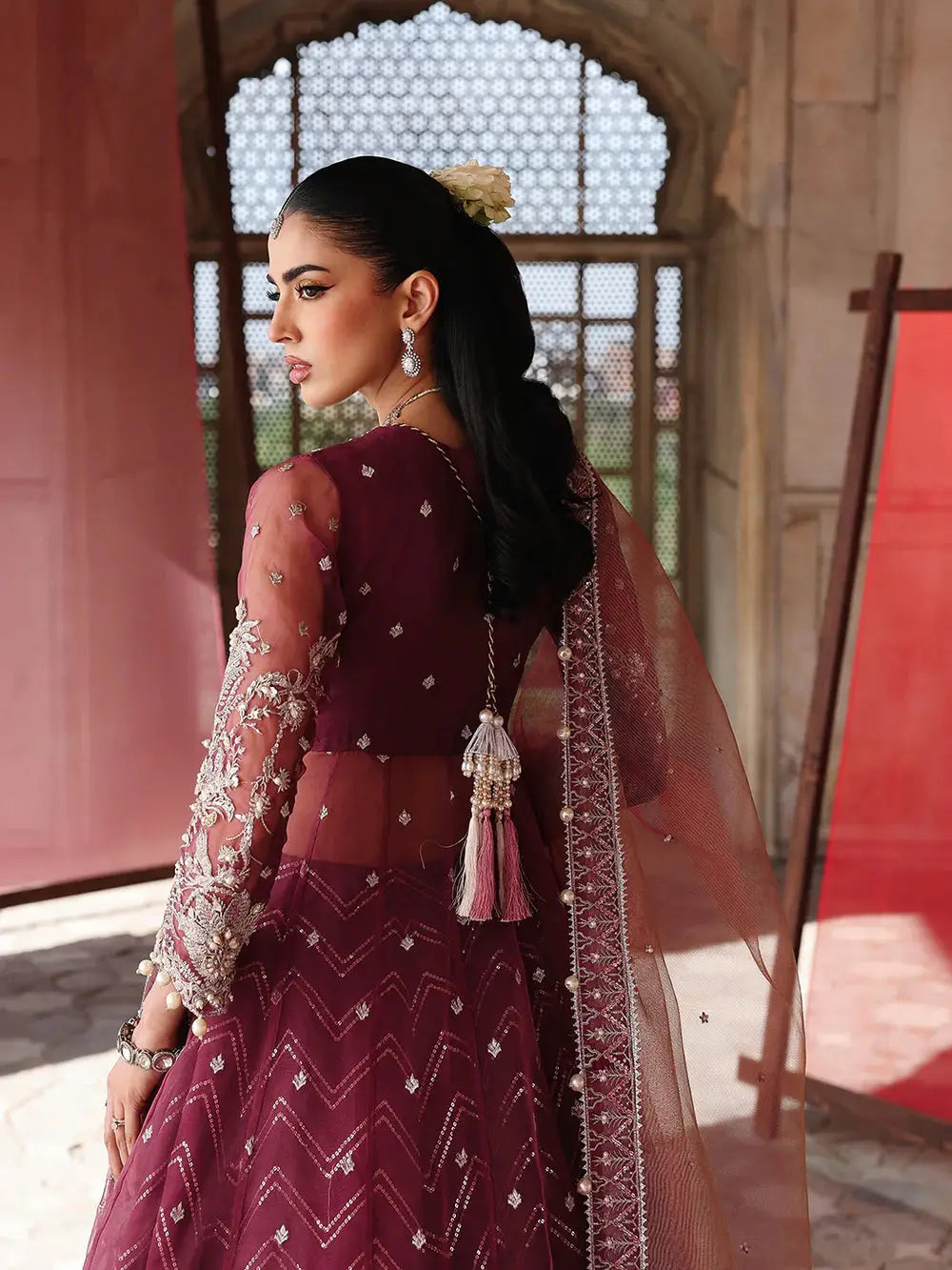 Close-up of maroon embroidered lehenga with silver details and peach dupatta