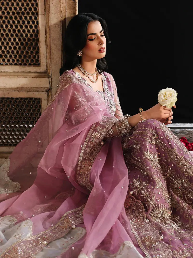 Pink embroidered traditional dress with jewelry and sitting pose