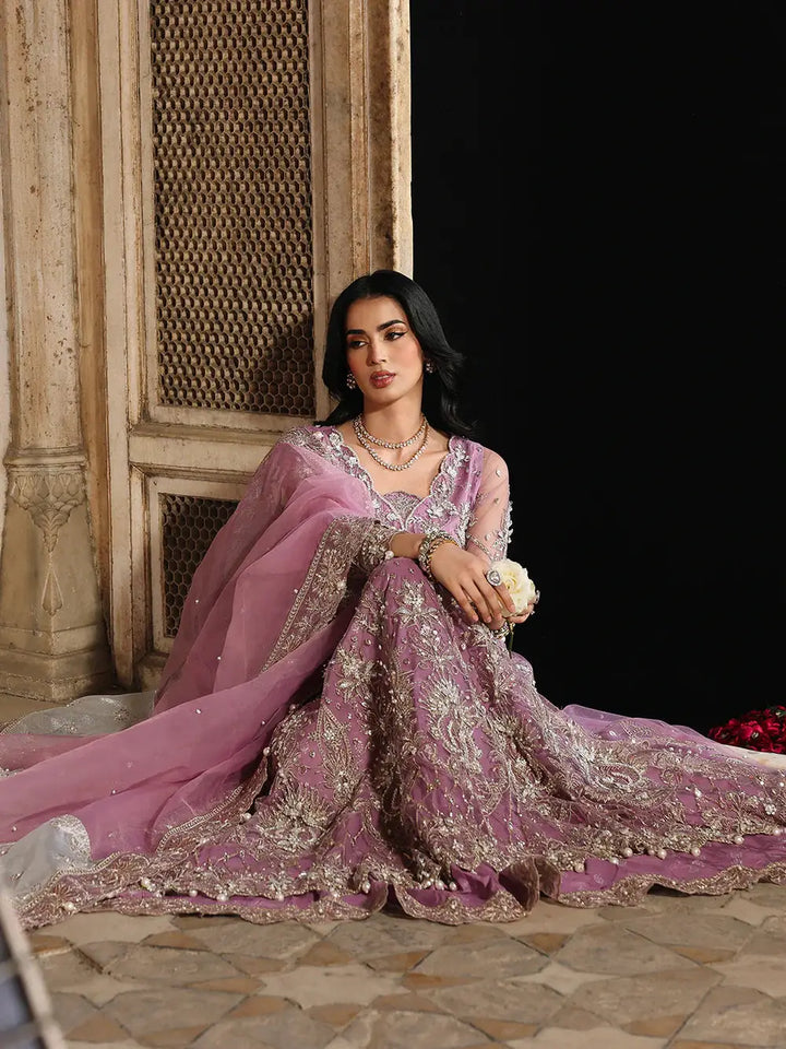 Pink embroidered traditional dress with jewelry and sitting pose