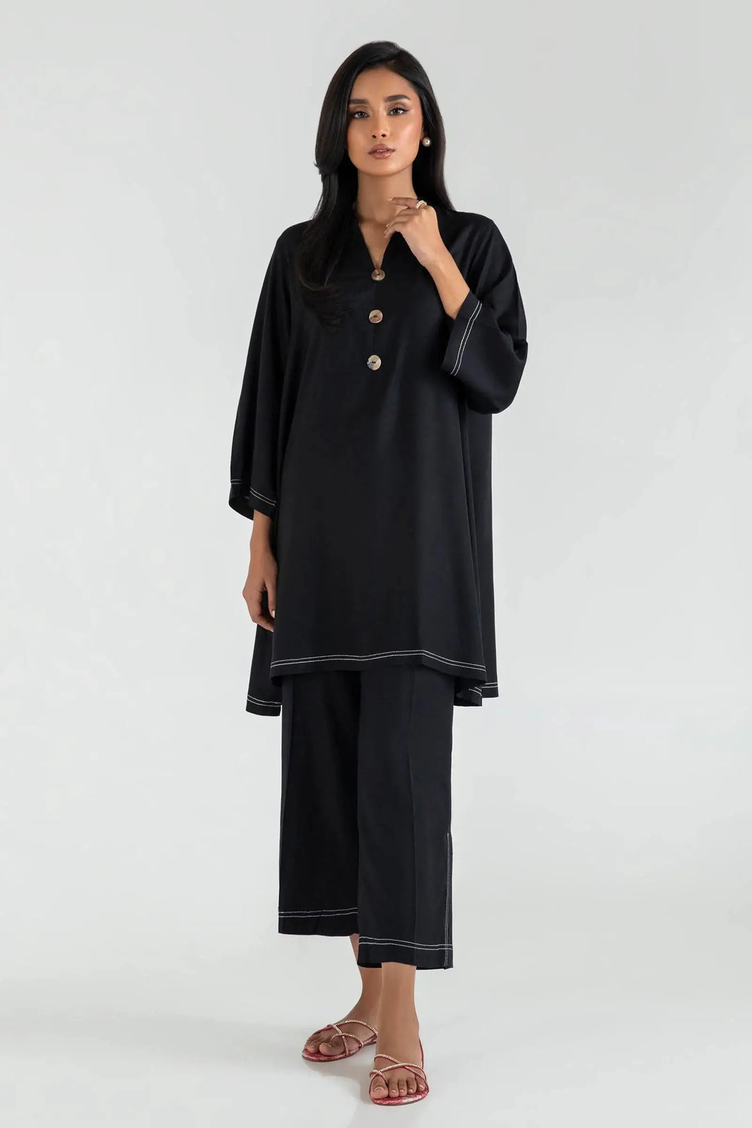 Woman wearing a black outfit with a plain background