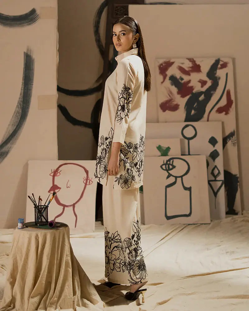 Side view of EA-19 raw silk co-ord set with black floral prints on cream fabric, perfect for semi-formal Eid wear in Pakistani fashion.
