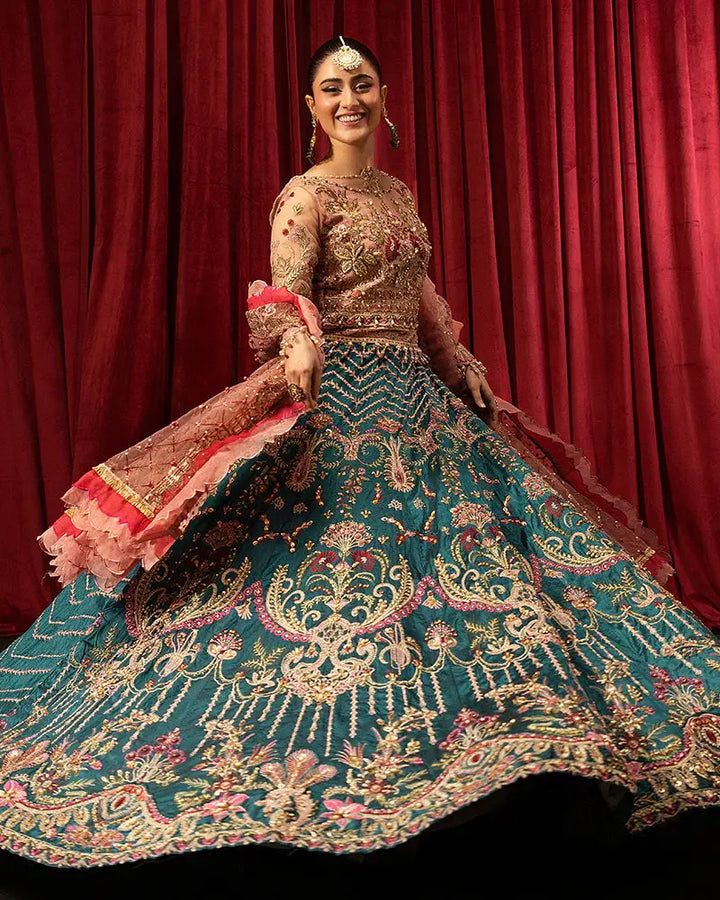 Model twirling in AROOSH FAANA AR-97-3500 lehenga set with vibrant teal and gold embroidery, perfect for weddings and celebrations.