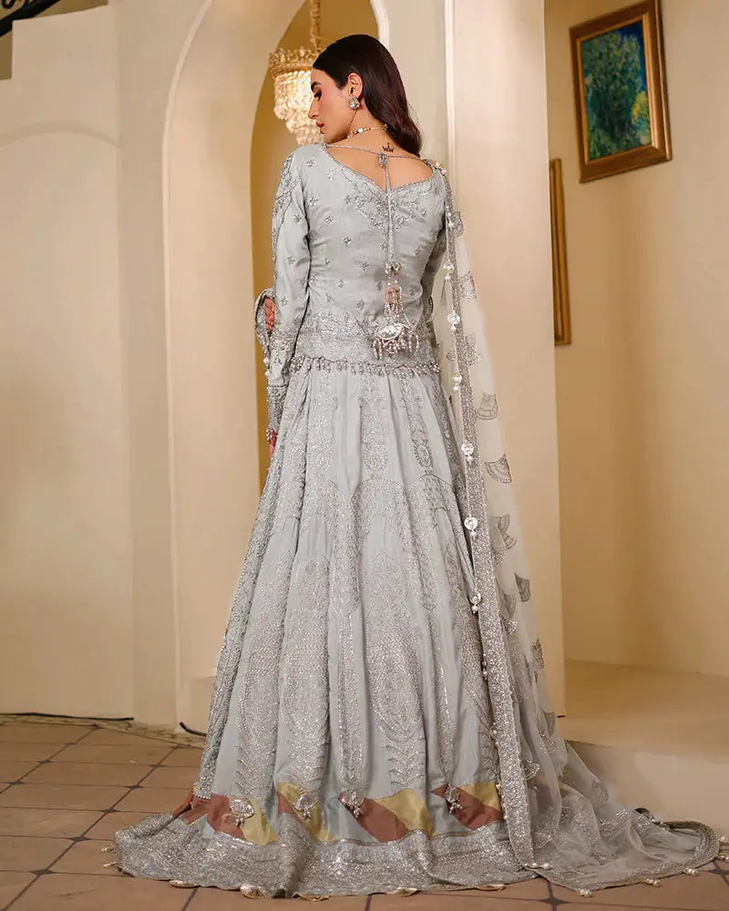 Back view of AROOSH WEDDING WEAR Raw Silk Choli bridal outfit featuring intricate embroidery, flared lehnga, and embellished dupatta in silver tones.