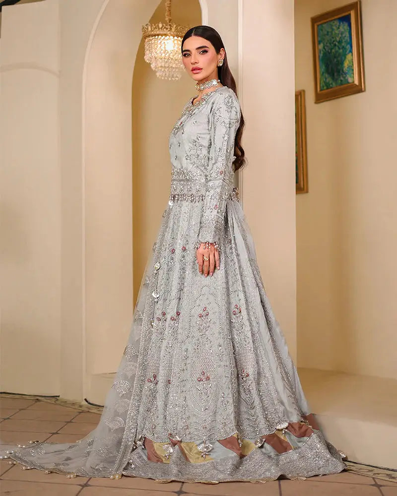 Side view of AROOSH WEDDING WEAR Pakistani bridal dress featuring flared lehnga, detailed hemline, and shimmering embellishments on Raw Silk Choli.