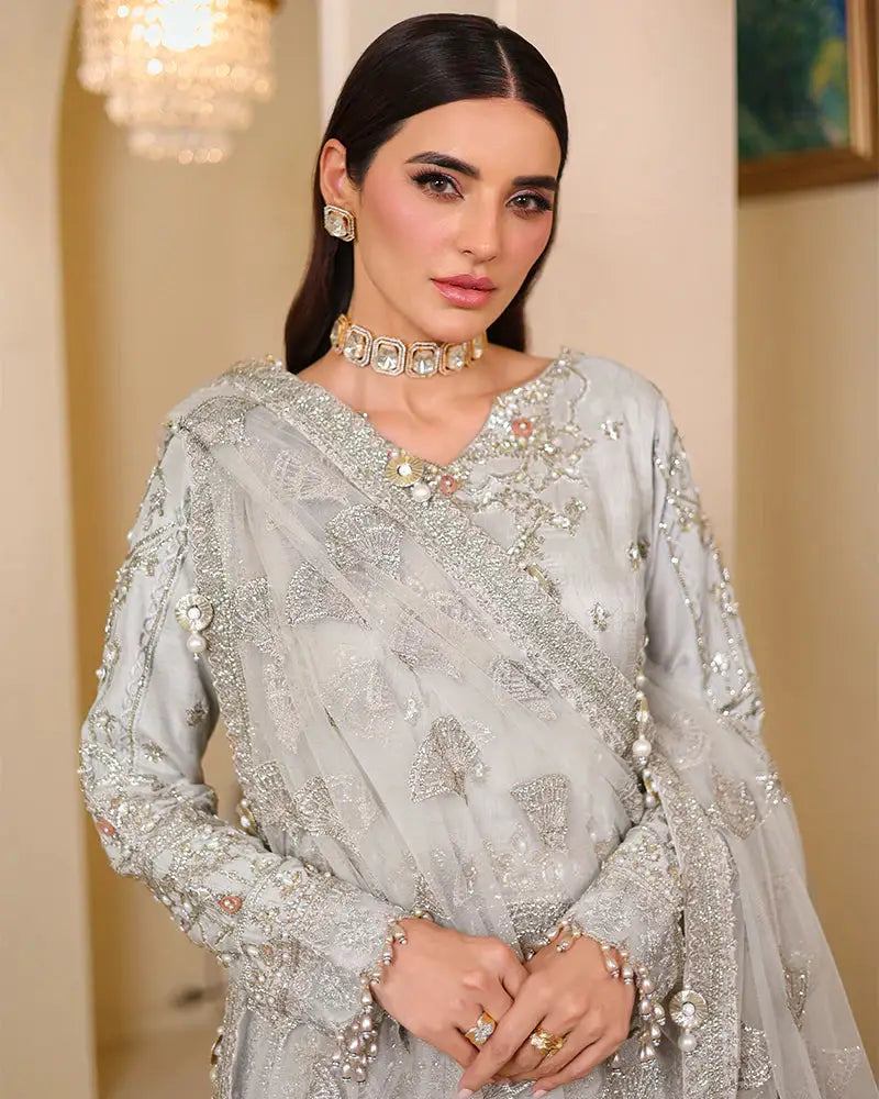 Detailed close-up of AROOSH WEDDING WEAR Raw Silk Choli bridal outfit highlighting pearl accents, tilla embroidery, and sequined dupatta design.