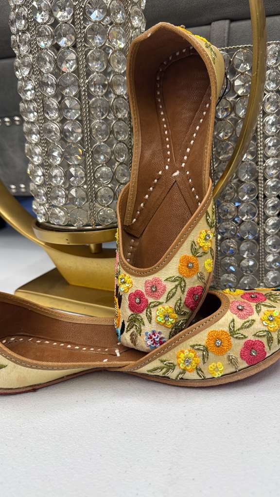 Rangreza's Jhoom Yellow Jutti featuring vibrant hand-embroidered flowers, perfect ethnic footwear for pairing with formal Western wear.