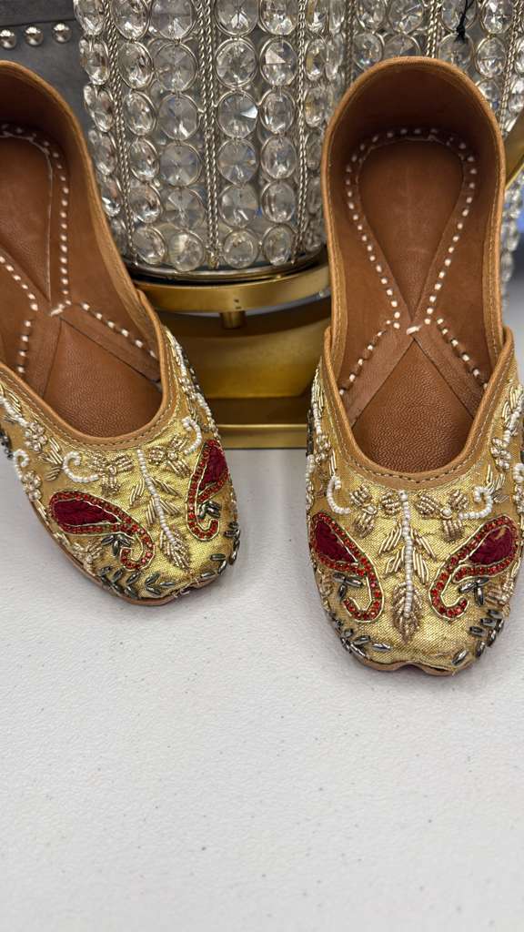 Roshni Golden Jutti flats with intricate gold and red threadwork, perfect festive footwear in the Apparel & Accessories > Shoes > Flats category.