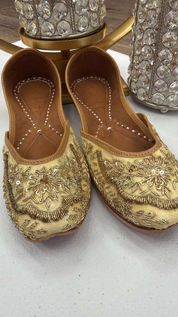 Rawa Golden Jutti featuring ornate zari work and khussa style. Elegant handcrafted flats perfect for weddings and traditional occasions.