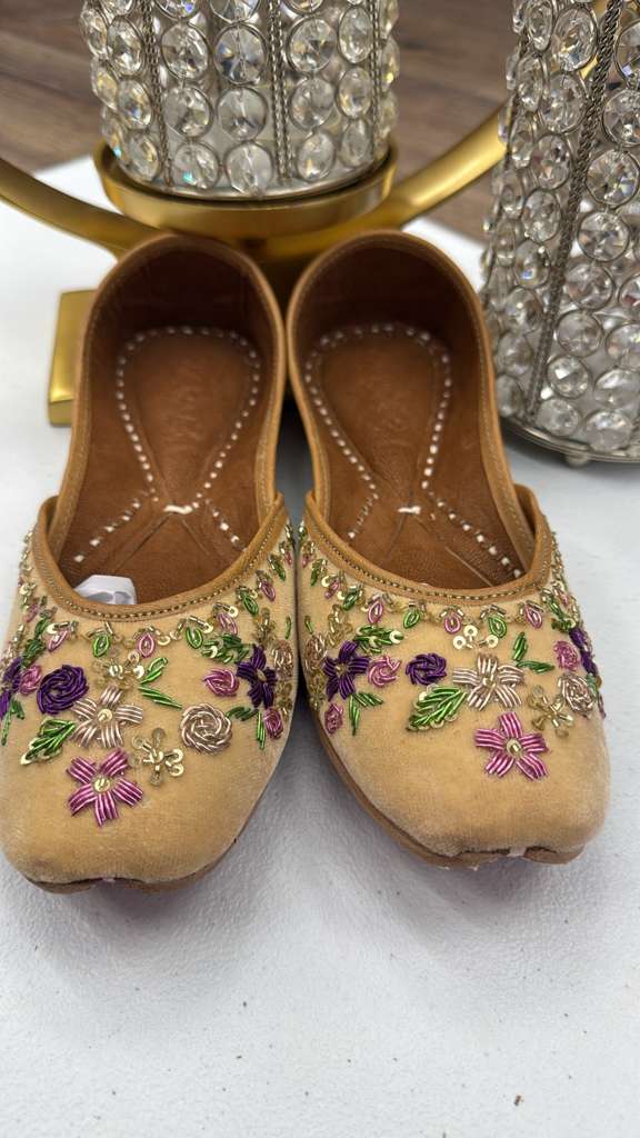 Traditional Shahi Yellow Jutti for women featuring handcrafted velvet base and metallic thread floral detailing in purple and green tones.