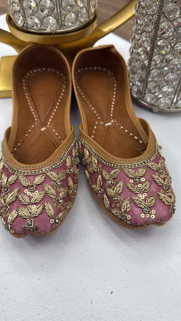 Elegant Zoya Rose Pink Jutti featuring intricate gold Zari embroidery, perfect handcrafted khussa flats for women’s ethnic outfits.