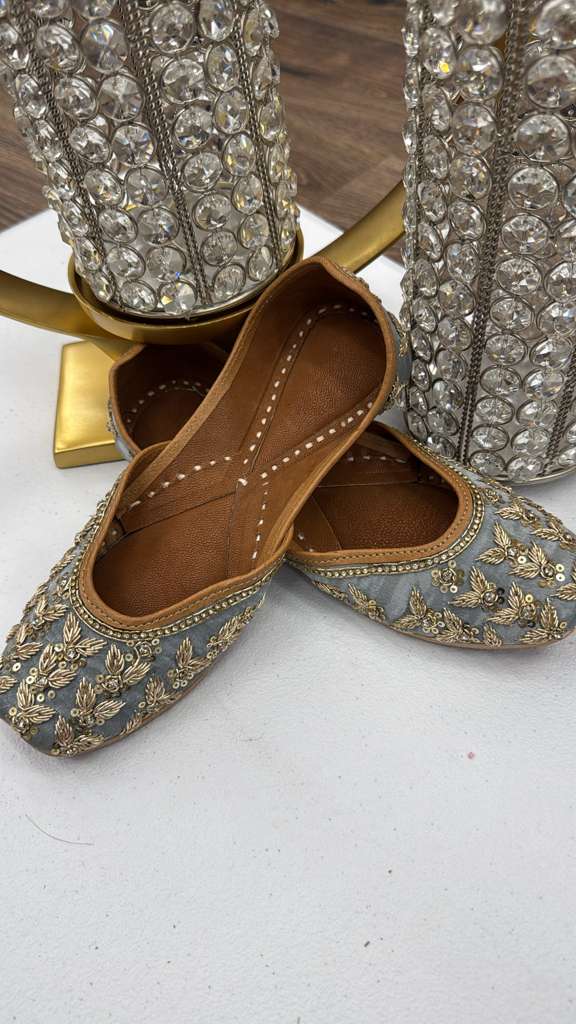 Shop Rani Grey Jutti - Pakistani Khussa Shoes in silver-grey with gold zari embroidery and sequins, perfect for ethnic wear. Elegant flat footwear.