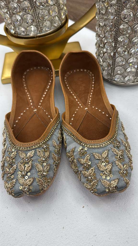 Rani Grey Jutti featuring intricate gold threadwork and sequin embellishments on silver-grey fabric. Traditional Pakistani khussa flats for women.