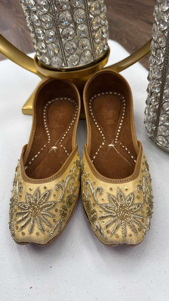 Elegant Raeesa Golden Jutti featuring detailed gold embroidery and sequin embellishments, perfect for ethnic and festive wear.