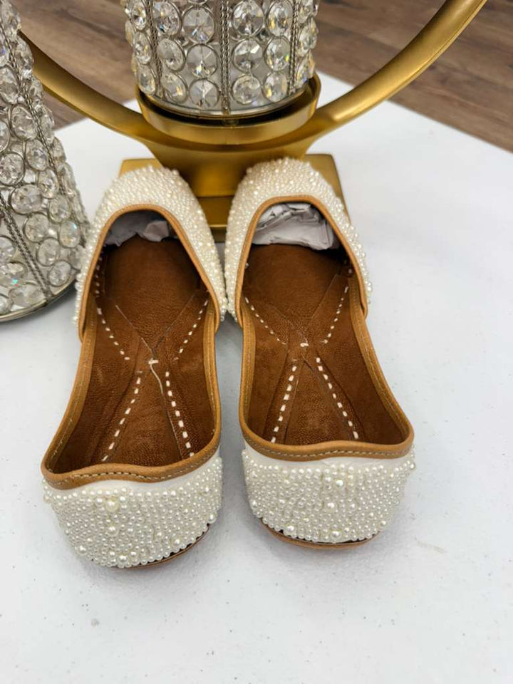 Back view of elegant white Khussa Jutti featuring intricate pearl detailing, ideal for weddings and festive occasions. Traditional flat footwear.