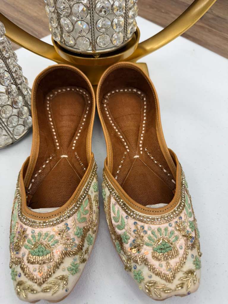 Close-up of Mehrunnisa Gold Jutti featuring intricate gold thread and mirror work. Elegant Khussa flats for traditional and festive wear.