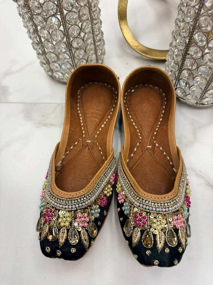 Elegant Barooque Black Jutti featuring luxury pearls, floral beadwork, and handcrafted detailing, perfect for traditional and chic occasions.