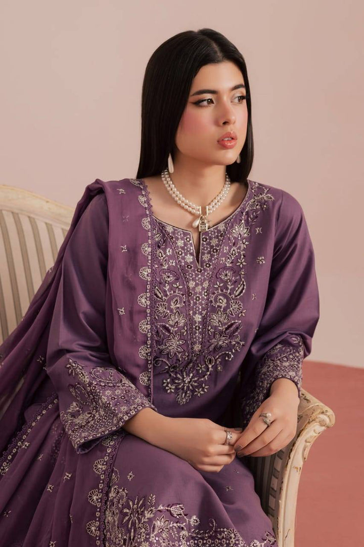 Model seated in BATIK Deraya 3Pc embroidered khaddar dress, showcasing elegant craftsmanship and winter-ready fashion appeal.
