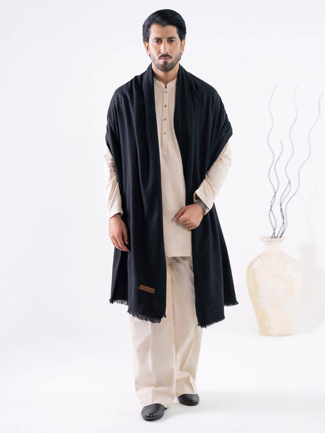 Shop ALMIRAH Casual Black Pakistani Shawls Men | Winter Collection featuring a black shawl draped over a cream traditional outfit, ideal for cold weather.