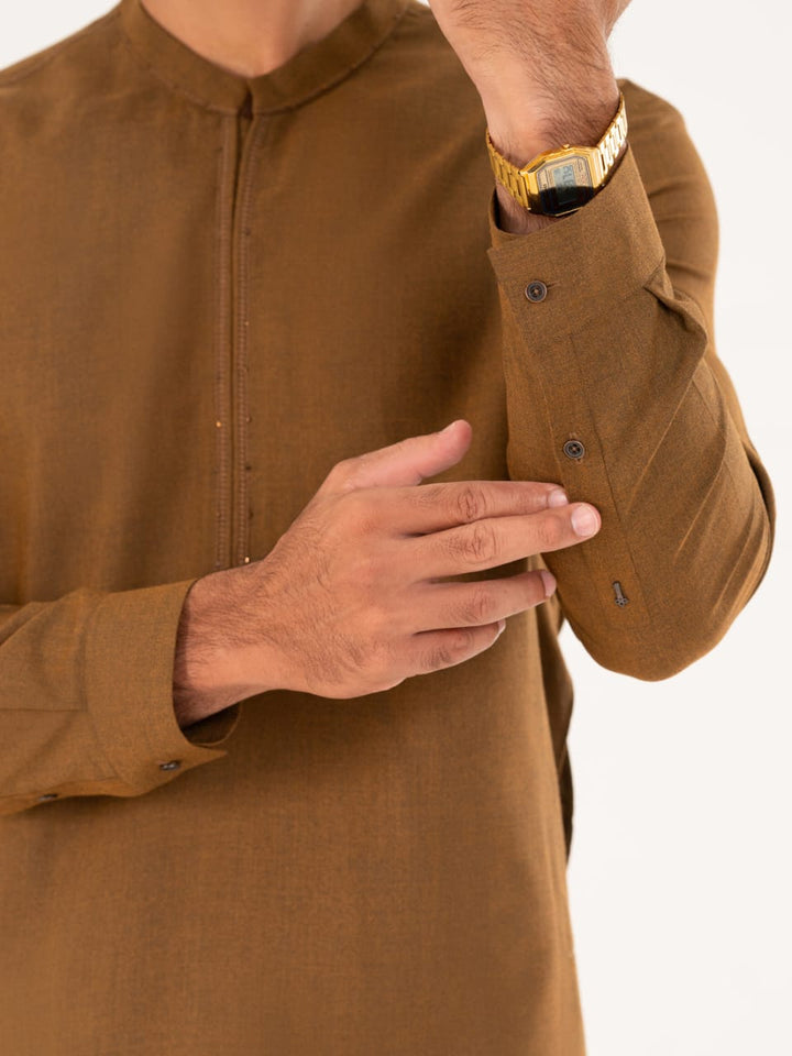 Detailed view of ALMIRAH brown kameez sleeve with buttoned cuff, part of the semi-formal men's shalwar kameez set.