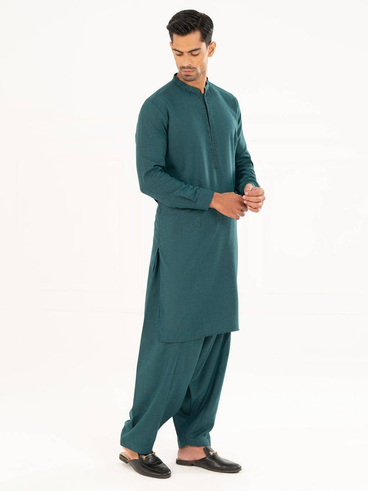 Side pose of ALMIRAH green kameez shalwar for men, featuring a straight cut and traditional styling for semi-formal occasions.