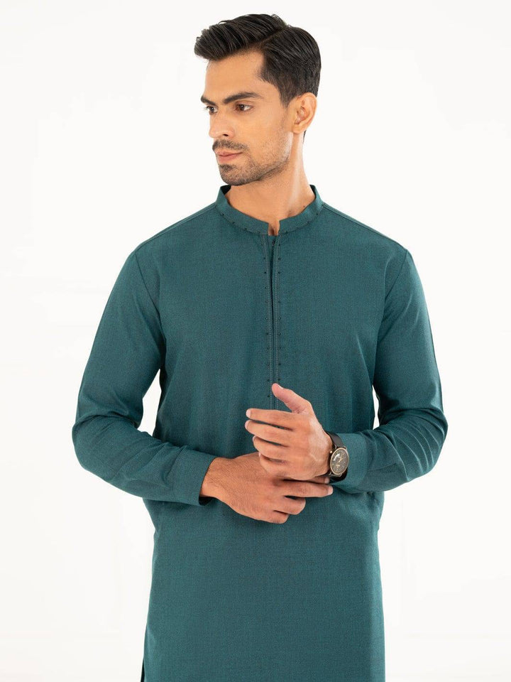 Close-up of ALMIRAH men’s kameez shalwar highlighting the neckline and button detailing on the green band collar shirt.