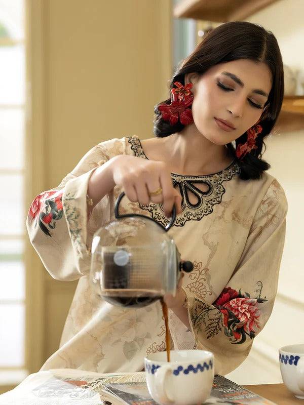 Woman pouring coffee in Rangreza silk 2-piece with floral sleeves and beige background